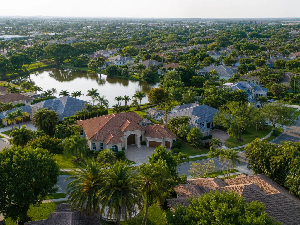 Aerial view of a Florida subdivision with tile and shingle roofs among palms